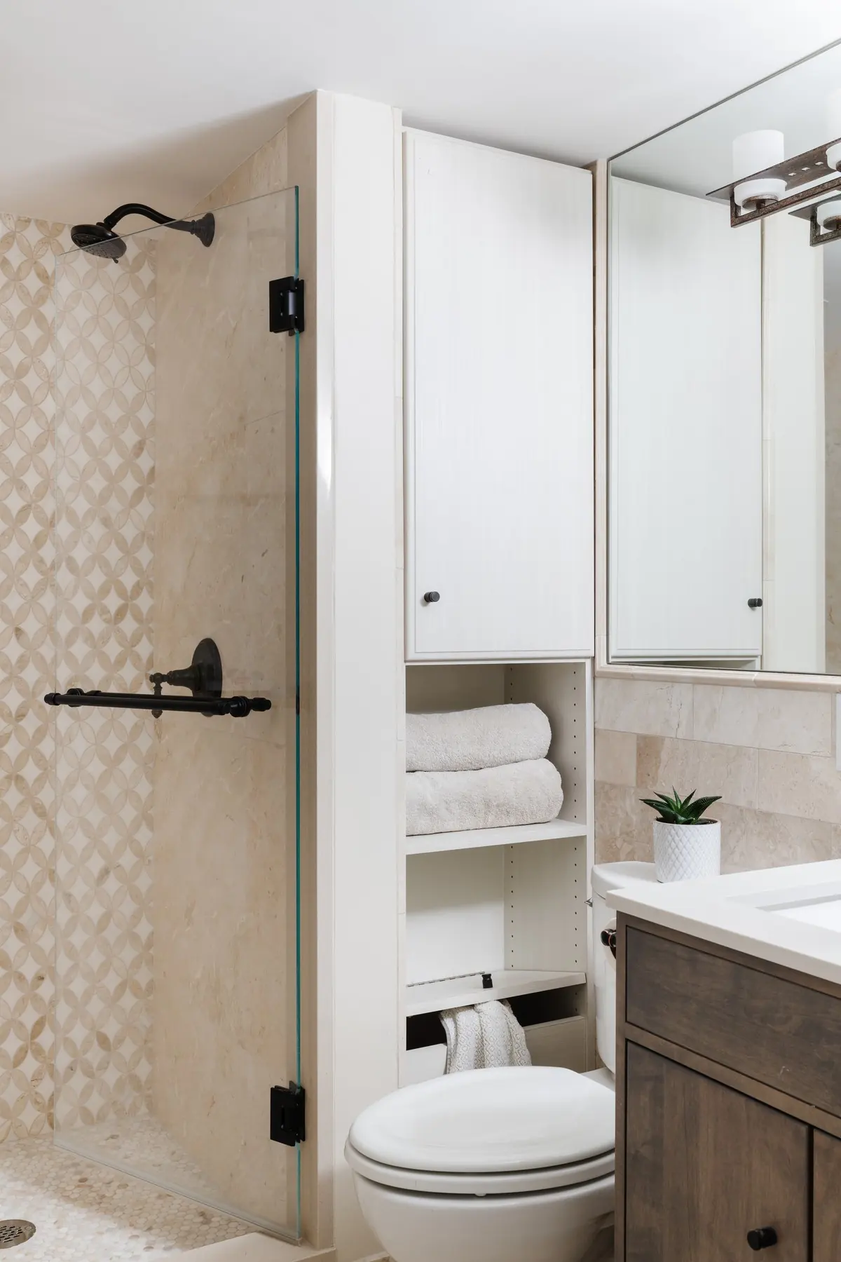 Bath with a glass shower and built-in linen storage