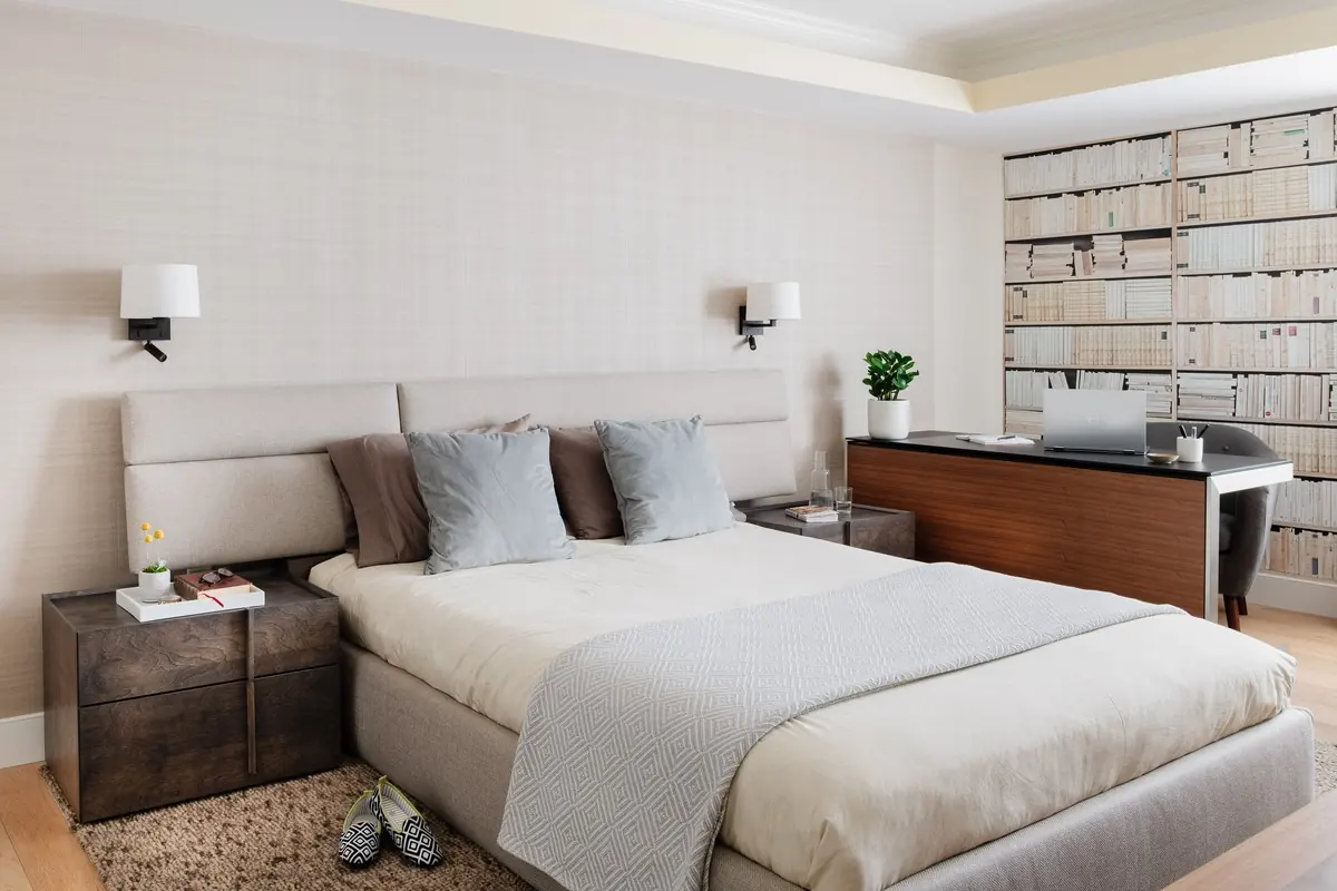 Bedroom with an upholstered headboard wall and a wood desk