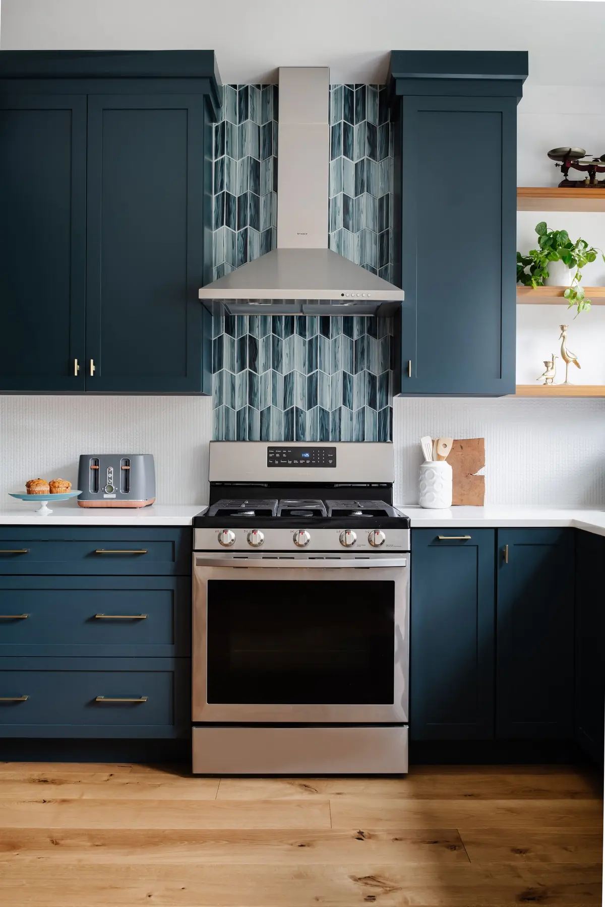 Deep blue cabinetry around a range with a teal tile backsplash