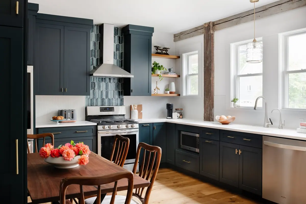 Kitchen with deep blue cabinetry and a rustic wood post and beam