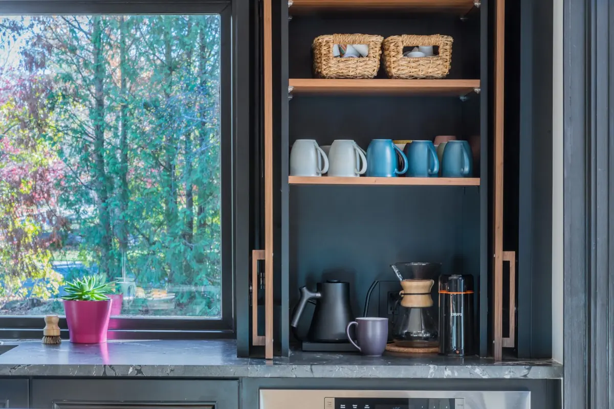 Built-in coffee station with open shelves and wood-framed doors
