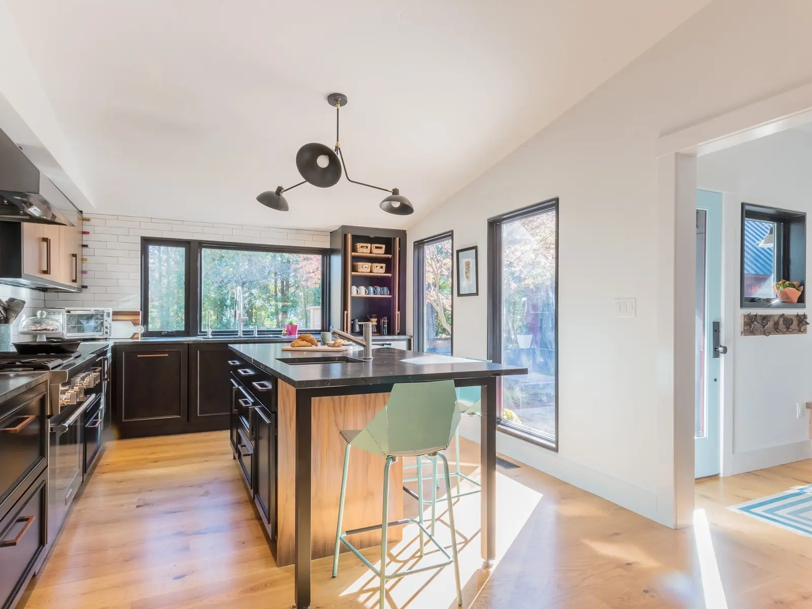 Kitchen with a wood-clad island, black-framed windows and a vaulted ceiling