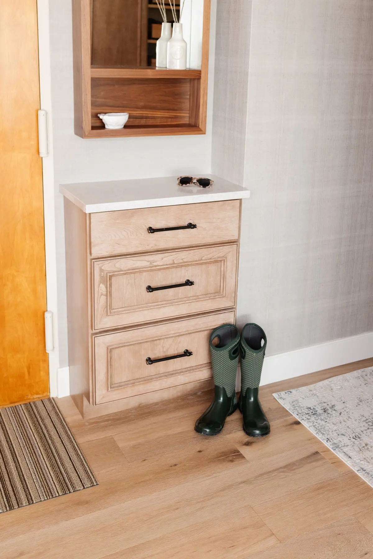 Mudroom drawers in natural wood under an open cubby