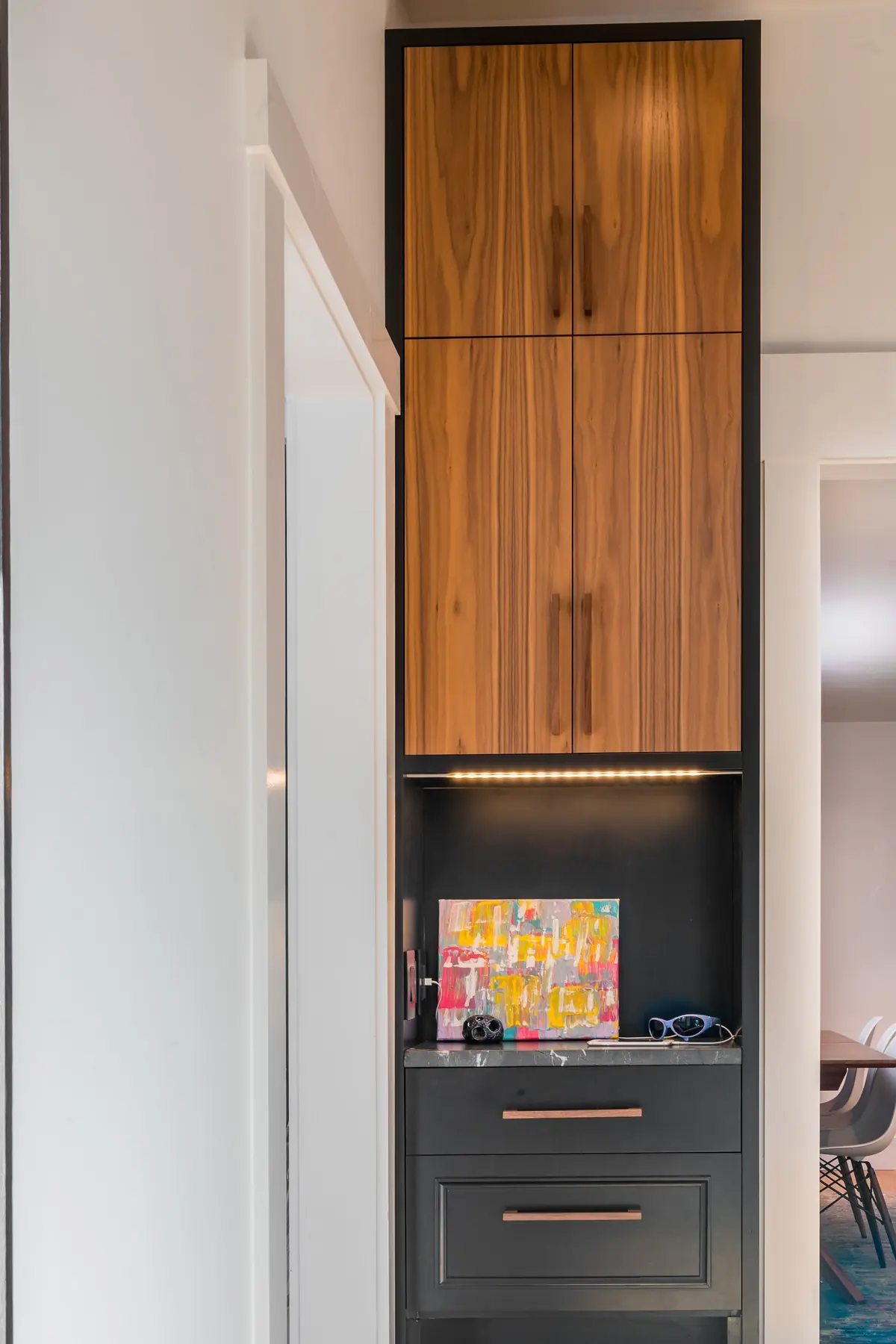 Floor-to-ceiling walnut cabinet framed in black